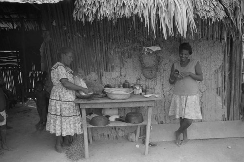Two women cooking in front of a table, San Basilio de Palenque, 1976