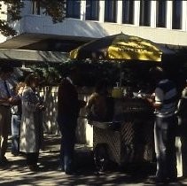 Views of redevelopment sites showing hotels, theaters, restaurants and other businesses. This view shows a hotdog stand outside a county building