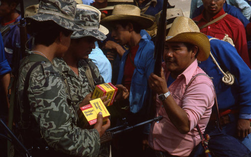 Two soldiers supplying shotgun shells for a Mayan civilian, Chajul, 1982