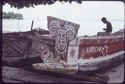 Canoes: "Kairiyewa" written on the side of kula canoe, carved and painted elements on prow and sides