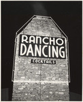 [Exterior night shot of Riverside Rancho, sign on brick chimney, 3213 Riverside Drive]