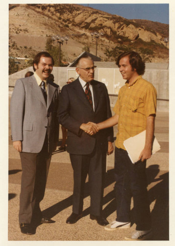 Unknown Man, Dr. Earl Butz shaking hands with a man student