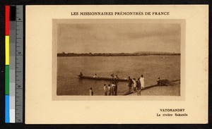 People standing on the shore of a river, watching a small boat put out, Madagascar, ca.1920-1940