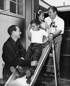 Abbott and Costello play with children on a slide, East Los Angeles Recreation Center, 1948