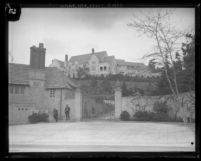 View of front gates, hillside, and Greystone Mansion on top of hill in Beverly Hills, Calif., 1929