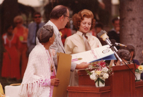 Kenneth Hahn honoring Betty Ford and Pearl Williams during foster grandparents ceremony, 1975