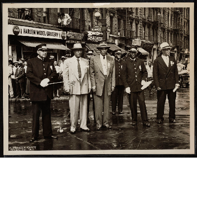 Group photograph in rainy street at W. 144th St.(left-right): W.C. Mills, A. Philip Randolph, Thomas T. Patterson, Ashley L. Totten, W.H. Sanders, H.A. Rock