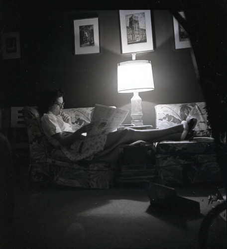 Woman on the couch reading a newspaper