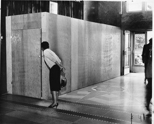 Woman peeks through door at Federal Building / Post Office, 300 N. Los Angeles St., Los Angeles, 1959