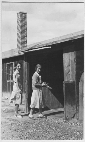 Two women enter camp building