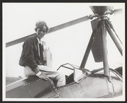 Amelia Earhart sitting on her Beech-Nut plane