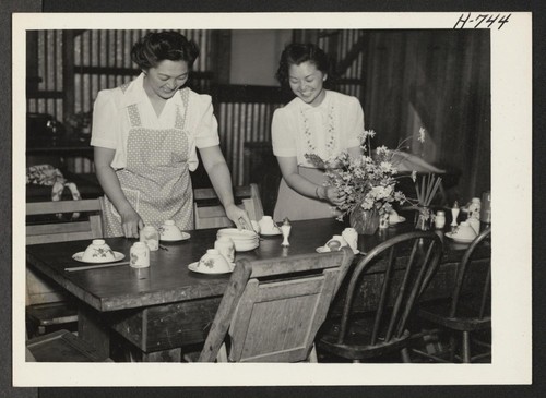 Mrs. Mary Terada (left) and Miss Yuri Kawakami, both of Heart Mountain, set the table at the Civic Unity Hostel in San Jose. Mrs. Terada, with her husband and two young daughters, arrived on June 7. They are stopping at the hostel while looking for a house. Photographer: Mace, Charles E. San Jose, California