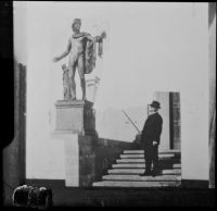 Henry E. Huntington in front of the library building of his estate pointing towards a bronze cast of the Apollo Belvedere, San Marino, (circa 1927, orig. photo.)