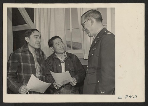 Captain William S. Fairchild discusses the Army with a couple of young Nisei volunteers about to fill out their enlistment