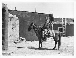 Navajo father and daughter sitting on a pony visiting a Hopi village, ca.1901