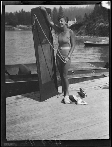 Young woman with aquaplaning board and dog, Lake Arrowhead, 1929