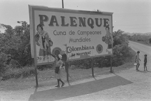 Woman standing next to billboard, Cartagena Province, ca. 1978