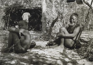 An old chief and a boy, sat on a forest path