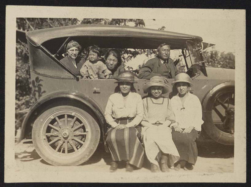 Group posing inside and outside of car