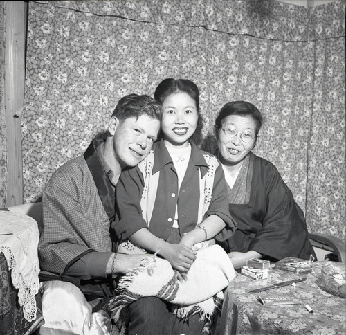 Soldier posing with two women in a Japanese teahouse