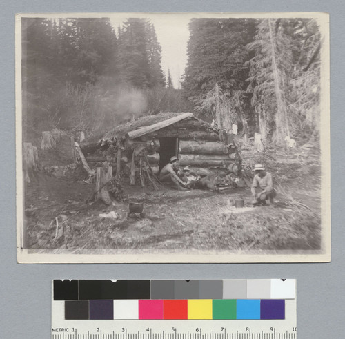 Three men in front of log cabin, Idaho trip. [photographic print]