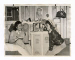 Two girls sitting on beds in the barracks at Manzanar