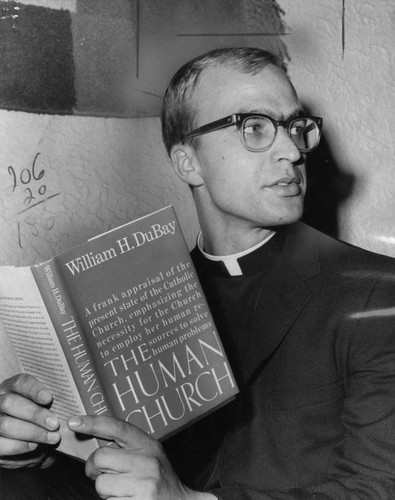 Father William DuBay with his controversial book