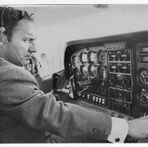 Dr. Alvin Marks, pilot and owner of Skymark Airlines. Here, Marks talks on the radio, in the cockpit of his plane