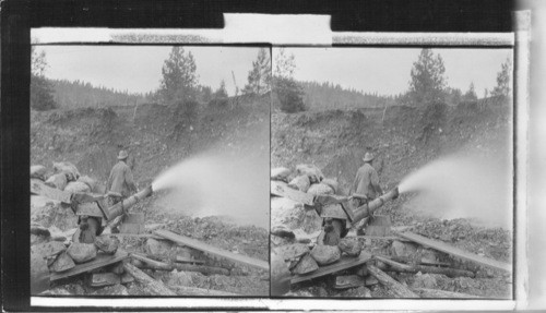 Attacking a gold bearing gravel bank with a 4-inch stream. Oregon
