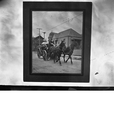 Fireman riding on horse-drawn fire wagon