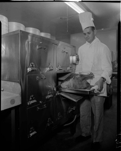 Chef removing turkey from oven