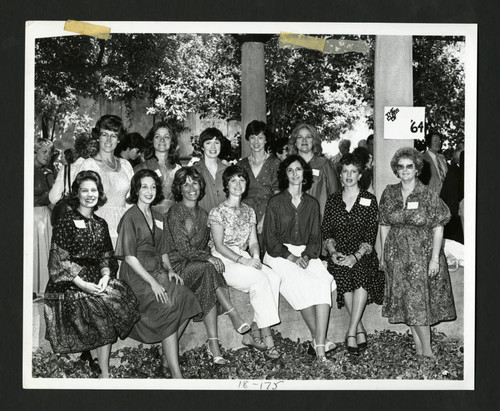 Scripps alumnae sitting together by a class of '64 sign in Margaret Fowler Garden, Scripps College