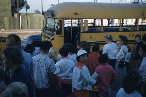 Men, women, and children in front of bus