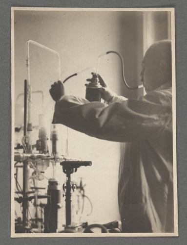 [Otto Stern in laboratory, adjusting tubes.]