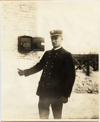 [Chief Murphy of the San Francisco Fire Department standing next to a fire alarm at the Panama-Pacific International Exposition]