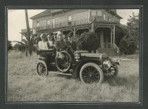 People in touring attire seated in automobile
