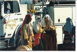 Four men in "Arab"' costumes stand in front of Twin Hills Fire District engine 341 in the Apple Blossom Parade in Sebastopol