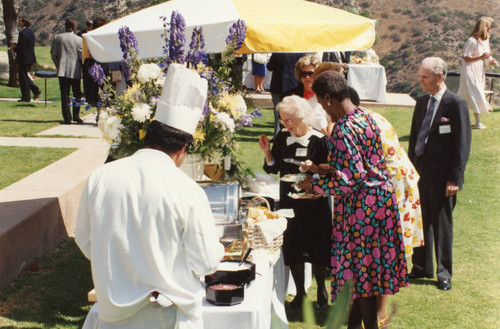 Guests serving themselves at the buffet on the Broch House lawn (Pose 1)