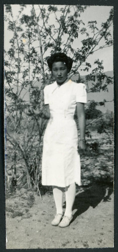Photograph of a nurse posing in front of a tree at Manzanar
