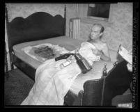 Edwin Gaffney covered with blanket and liquor bottles, reclining on mattress he set on fire at hotel in Los Angeles, Calif., 1948