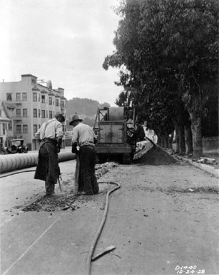 [Workers breaking concrete base during pipe installation along the side of Masonic Avenue, near Golden Gate Avenue]