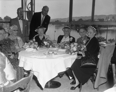 Women seated at tables over-looking Lake Merritt
