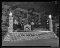 Four women pose on the San Diego County display at the National Orange Show, San Bernardino, 1933