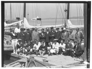 A group of men on a dock in front of yachts