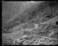 Gold miner M.L. Sims with wheelbarrow and shovel, San Gabriel Canyon, 1932