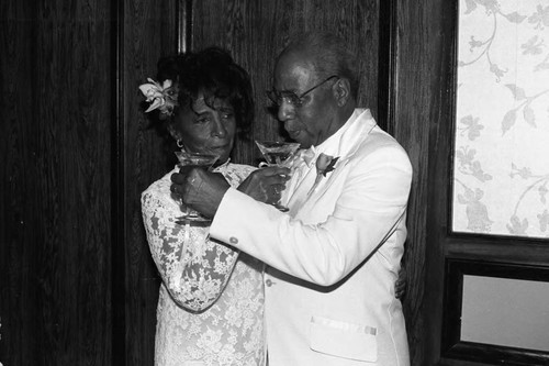 James and Odessa Bohana sharing champagne at their 50th wedding anniversary celebration, Los Angeles, 1984