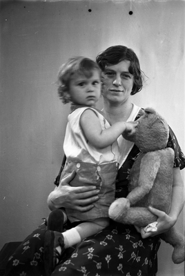 Portrait of a woman holding girl and stuffed teddy bear