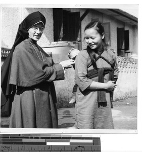 A Maryknoll Sister with a family at Guilin, China, 1949