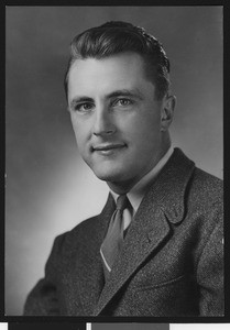University of Southern California assistant football coach Roy Engle, studio shot, wearing a dark flecked suit and tie with one stripe, Los Angeles, 1946