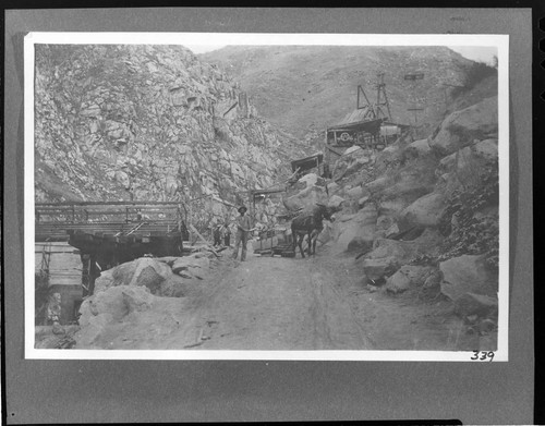 A man standing by a mule hauling a sledge of supplies for the powerhouse construction at Kern River #1 Hydro Plant